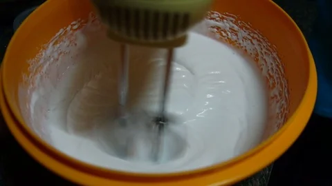 Slow motion, mixing batter with lightweight hand mixer. Stock Footage 111563791
