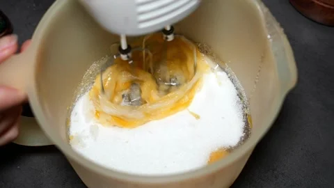 Slow Motion Mixing Sugar and Eggs with Hand Mixer Video stock 320393582