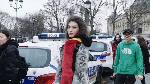 Slow motion of model posing in front of police car outside Chanel's Paris Stock Footage 97183899