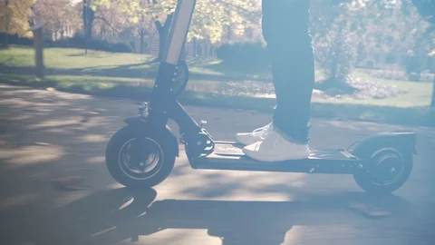 Slow Motion of Modern Man Using Electric Scooter in Sunny Park 4 Vidéo 98757687
