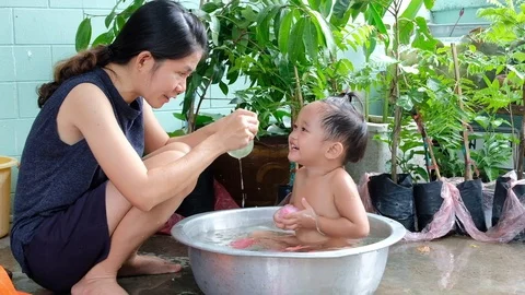 Slow motion. Mom is bathing her children and teasing laugh them happily. Stock Footage 109829920