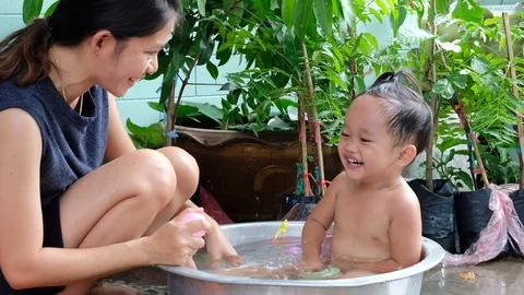 Slow motion. Mom is bathing her children and teasing laugh them happily. Stock Footage 110255268