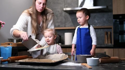 A slow-motion mom removes the cookie dough from the baking sheet, places it Stock Footage 289519285