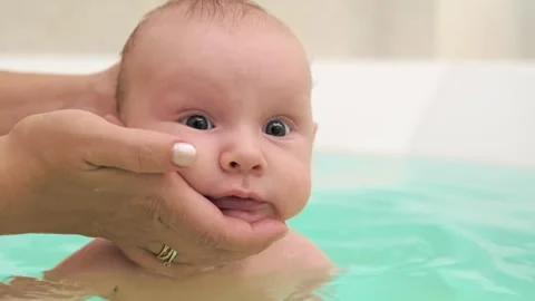 SLOW MOTION: Mom teaches a newborn baby to swim and stay on the water. Two-.. 스톡 동영상 254652364