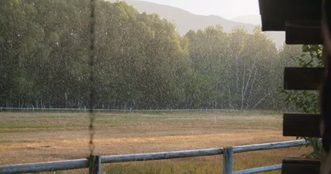 Slow-motion morning hail over a fenced field in an Idaho ranch Stock Footage 138485341
