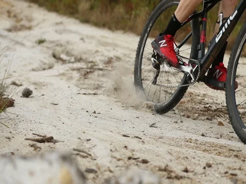 Slow motion mountain biker kicking up dust and gravel when taking a corner Stock-Footage 77578853
