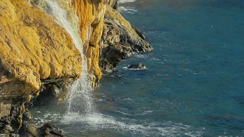 SLOW MOTION: mountain waterfall slowly flows into the sea view. Stock Footage 84037043