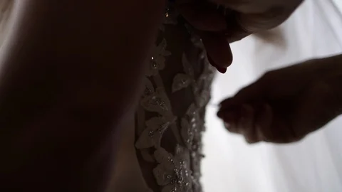 Slow motion move away from wedding dress being zipped close 動画素材 112140321