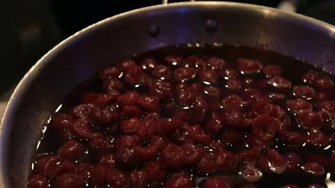 Slow motion move over hot bubbling cherries in pan Vídeos de archivo 107244371