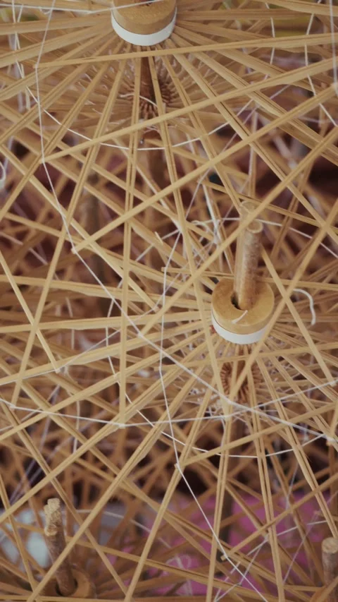 Slow motion movement of bamboo ribs and threads inside a handmade umbrella frame Stock Footage 328483578