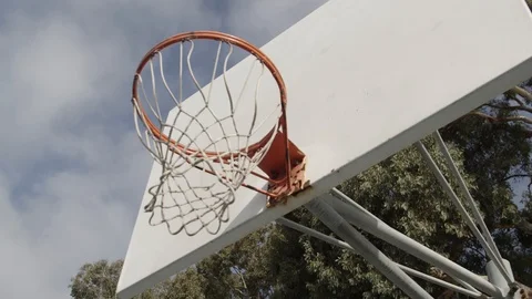 Slow motion movement under neath a basketball hoop looking up at the hoop Video stock 89874846