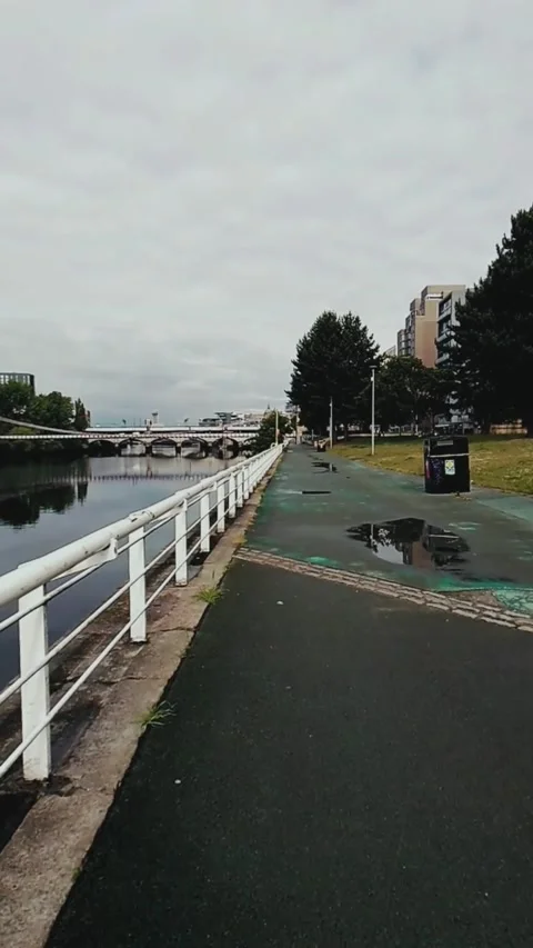 Slow motion moving along a riverside walkway - Vertical Video Stock Footage 200400260