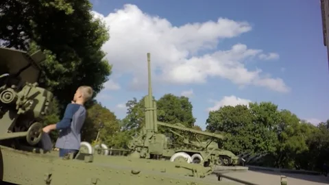 Slow motion, Moving the camera. The boy is played with an artillery gun. Video stock 79739881