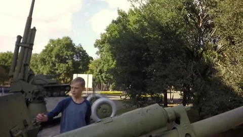 Slow motion, Moving the camera. The boy is played with an artillery gun. Video stock 79739908