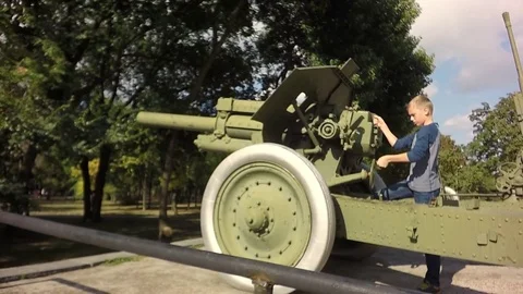 Slow motion, Moving the camera. The boy is played with an artillery gun. 库存影片 79739910