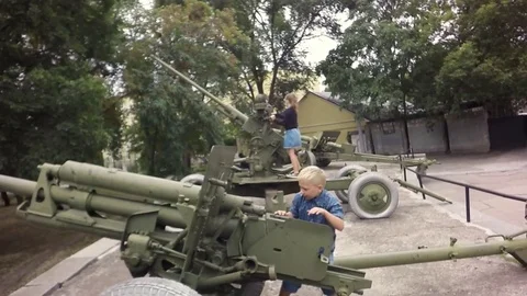 Slow motion, Moving the camera.  Children are played on an artillery gun. 库存影片 79469116