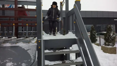 Slow motion, Moving the camera. Children are jumping into the snow. Snowing. Video stock 87544865