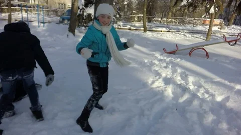 Slow motion, Moving the camera. Funny children throw snow at each other. 库存影片 87543705