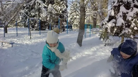 Slow motion, Moving the camera. Three children are fighting in the snow. Video stock 88242984