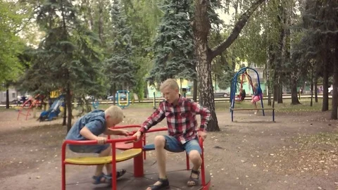Slow motion, Moving the camera. Two little boys ride on the merry-go-round. Stock-Footage 79753645