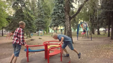 Slow motion. Moving chamber. Two little boy on a swing ride. Video stock 79753670