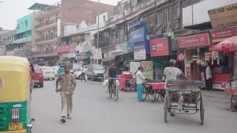 Slow motion moving shot of rickshaw pullers and people in Old Delhi street Vídeos de archivo 111559498