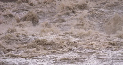 Slow-motion - Muddy stream overflowing its banks Camera tilt up Stock Footage 159304935