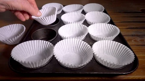 Slow motion – Muffin cases into a baking tray. Stock Footage 106431315