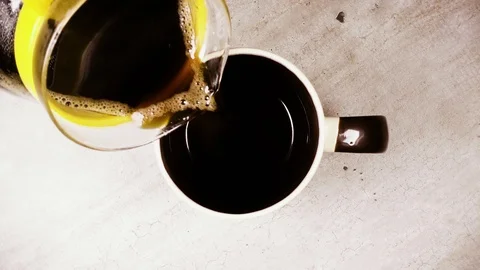 Slow motion in a mug pour coffee from a coffee pot top view Stock Footage 93940438