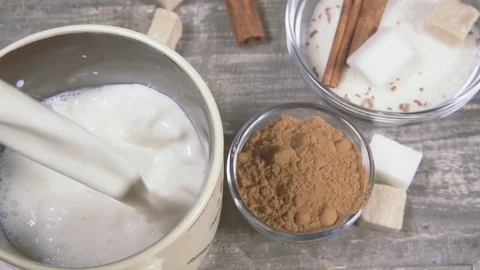 Slow motion in a mug pour milk near the ingredients for cocoa Stock Footage 95395079