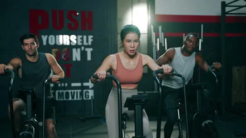 Slow motion of Multi ethnic group of young athletes training on stationary bike Stock Footage 151605114
