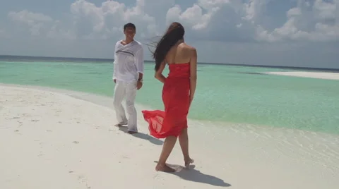 Slow Motion Of Multicultural Couple Running Along White Sandy Beach Stock Footage 45590907