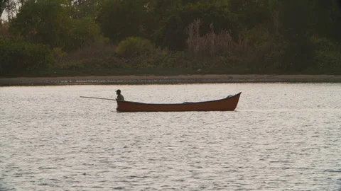 Slow motion of native man standing in water and pulling out his gondola, Mulki Stock Footage 145046271