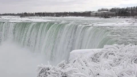 Slow motion of Niagara Falls covered in snow and ice during a polar vortex Stock Footage 328059351