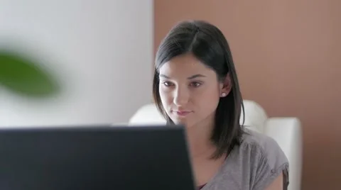 Slow motion of nice girl browsing laptop and answering phone at home close up Stock Footage 49833443