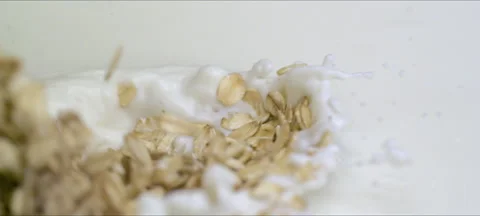 Slow motion oatmeal flakes falling into milk Stock Footage 323438965