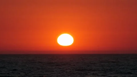 Slow motion ocean at sunset with sun in center frame Stock Footage 135003086