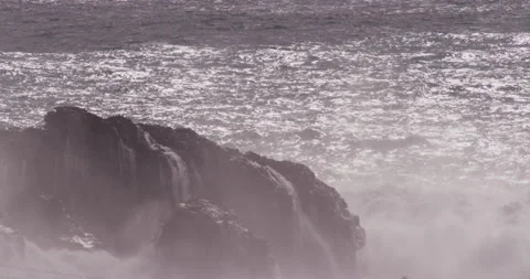 Slow motion ocean water surface lifting up and splashing heavily against cliffs Stock Footage 156140077