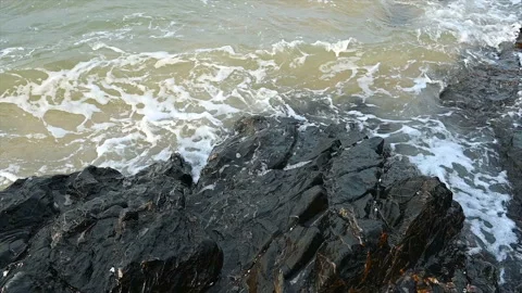 Slow motion ocean wave splashes across a big rock in the middle of the rough exo Stock Footage 155926133