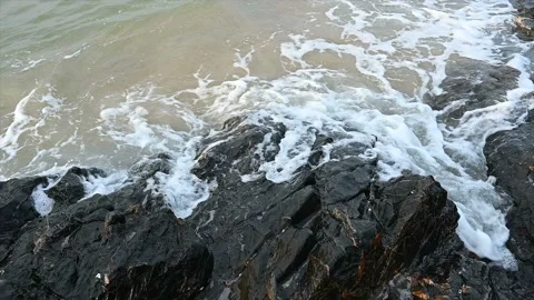 Slow motion ocean wave splashes across a big rock in the middle of the rough exo Stock Footage 155927250