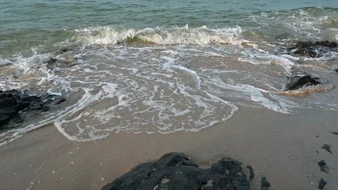 Slow motion ocean wave splashes across a big rock in the middle of the rough exo Stock Footage 165987360