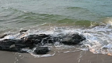 Slow motion ocean wave splashes across a big rock in the middle of the rough exo Stock Footage 194997497
