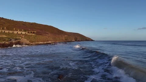 Slow Motion Ocean Waves Along Sunlit Coastal Hillside in 4K Stock-Footage 332944482