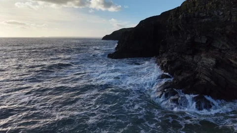 Slow Motion Ocean Waves Along Dark Rocky Coastline in 4K Видео 332944678
