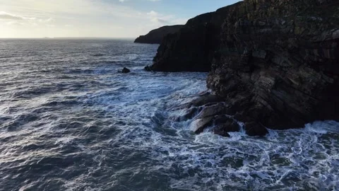 Slow Motion Ocean Waves Along Dark Rocky Coastline in 4K 스톡 동영상 332944711
