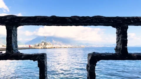 Slow Motion Ocean Waves and Distant Lighthouse Framed by Pier Railing Stock Footage 309203441