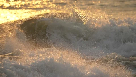 Slow motion ocean waves by beach at golden sunset. Close up Stock Footage 162766714