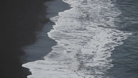 Slow Motion. Ocean waves calmly crushing on the black sand beach in Iceland. Stock Footage 283684276