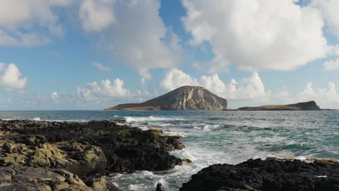 Slow Motion Ocean Waves Crashing on Rocky Shore with Island in Background Stock Footage 326003687