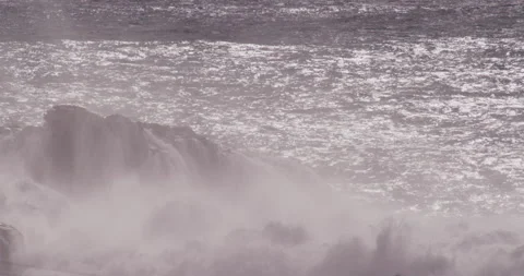 Slow motion ocean waves lifting up from water surface and washing over cliffs Stock Footage 156141091